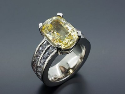 Oval Yellow Sapphire 7.47ct with 4.77ct of Step Cut White Sapphires in an 18kt White Gold Setting with Channel Set Band.