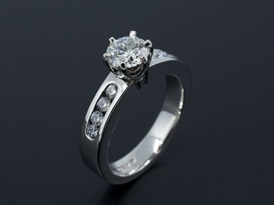 Round Brilliant 0.70ct F Colour SI1 Clarity Triple Excellent in a 6 Claw Platinum setting with Channel Set Side Diamonds.