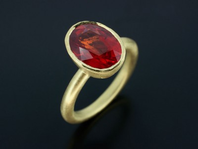 Blood Orange Sapphire 2.97ct in an 18kt Green Gold Rub Over Setting with Halo Shaped Band