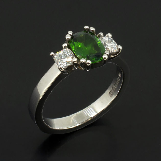 Cushion Cut Tsavorite 0.92ct and Cushion Cut Side Diamonds 0.20ct Total in a Platinum Claw Set Trilogy Design.