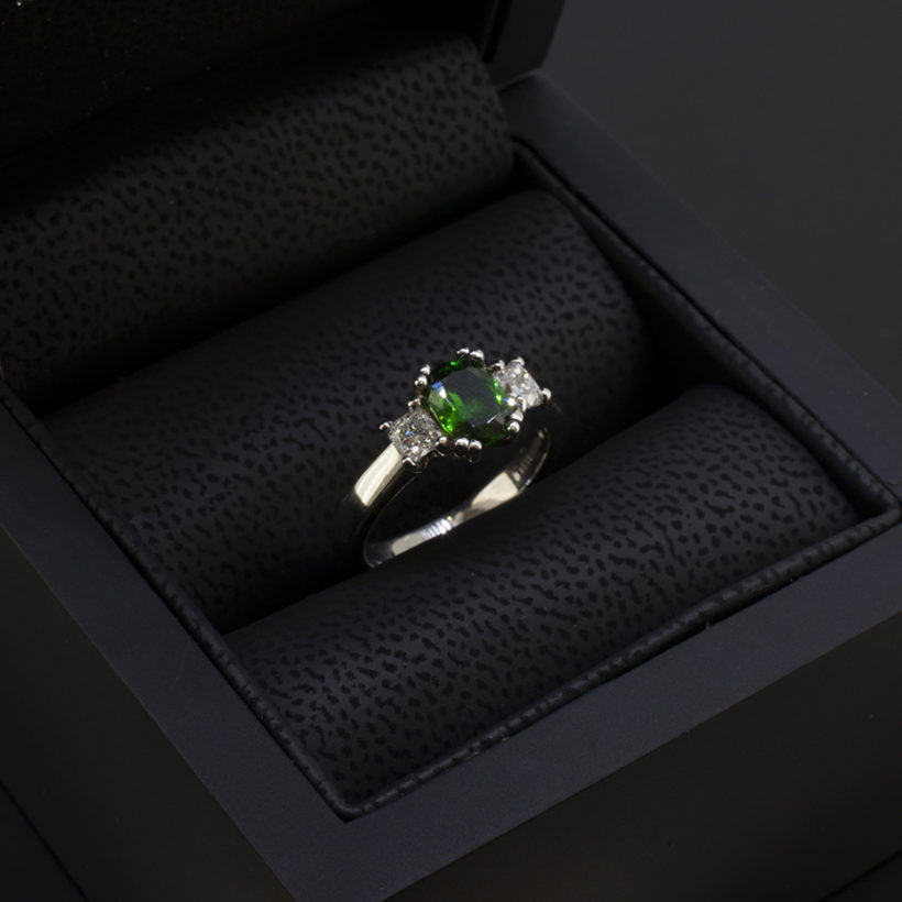 Cushion Cut Tsavorite 0.92ct and Cushion Cut Side Diamonds 0.20ct Total in a Platinum Claw Set Trilogy Design.