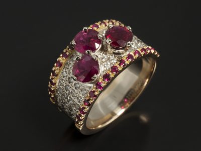 18kt White Gold Claw Set Round Brilliant Cut Rubies 1.94ct (3) with 18kt Yellow and White Gold Pave Set Round Brilliant Cut Diamonds 0.42ct (42) and Round Brilliant Cut Rubies 0.63ct (30) in a Dress Ring Design