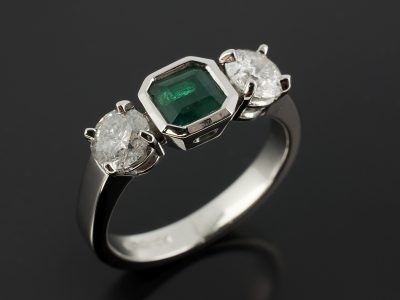 Emerald 0.65ct and Round Brilliant Cut Side Diamonds 0.52ct and 0.54ct F SI in a Platinum 4 Claw and Rub Over Set Design.