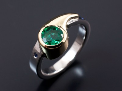 Round Emerald 0.81ct in 18kt Yellow Gold and Palladium Setting with 2 x Round Sapphires Secret Set into Band Ladies Ring