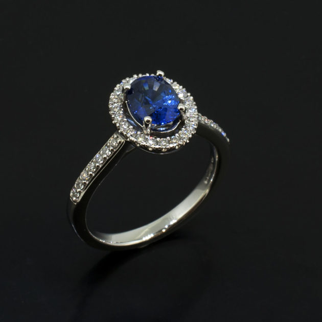 Oval Cut Sapphire 1.25ct with Round Brilliant Cut Diamonds 0.25ct Total in a Platinum Claw Set Halo Design.