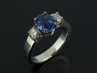 Oval Ceylon Sapphire 1.98ct with 2 x 0.25ct Round Brilliant Diamonds in a Palladium 4 Claw Trilogy Design.