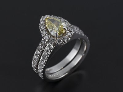 Fancy Intense Yellow 0.74ct VS1 Clarity Pear Cut Diamond in a Platinum Diamond Claw Set Halo Design with Fitted Diamond Claw Set Wedding Ring