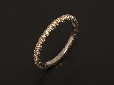 Platinum Full Claw Set Eternity Ring with Peach Coloured Diamonds.