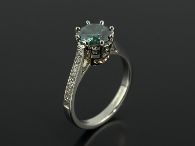 Round Brilliant 1.52ct Green Blue Diamond with Pavé Set Diamond Shoulders in a Platinum and Rose Gold Claw Set Design.