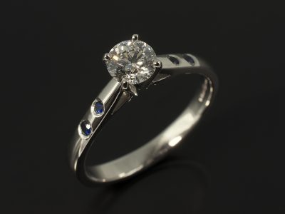 Round Brilliant 0.50ct D Colour VS2 Clarity EXEXEX with Round Brilliant Sapphires Secret Set into a Platinum Design.