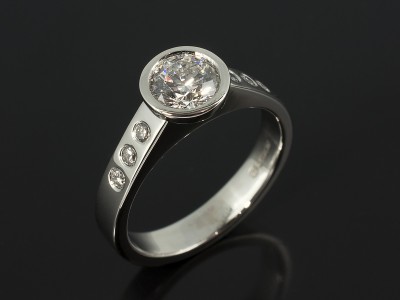 Round Briliant 0.76ct E Colour SI1 Clarity EXEXEX in a Platinum Rub Over Setting with Secret Set Diamond Shoulders.