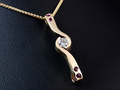 9kt Yellow Gold Secret and Tension Set Ruby and Diamond Twist Design Pendant, Round Brilliant Cut 0.40ct F Colour VS2 Clarity and 4x Rubies