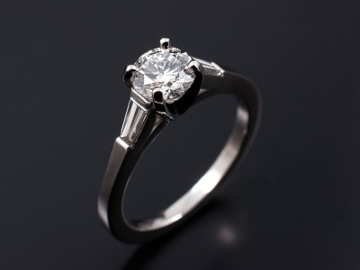 Round Brilliant 0.61ct G SI1 with 0.22ct (2) F VS Tapered Baguettes in a Platinum 4 Claw Setting.