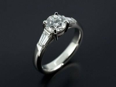 Round Brilliant 0.90ct D Colour SI2 Clarity Triple Excellent Grade with Tapered Baguettes 0.41ct Total in a Platinum Setting.