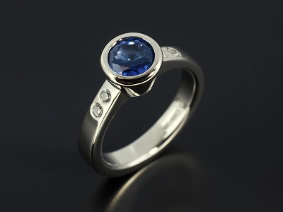 Round Sapphire1.06ct in a Palladium Rub Over Setting with Secret Set Side Diamonds.