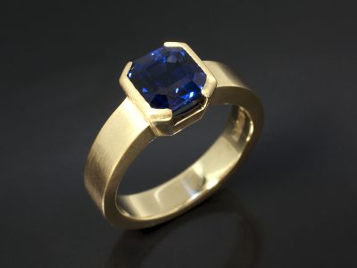 Asscher Cut Ceylon Sapphie 2.15ct in an 18kt Yellow Gold Brushed Half Rub Over Set Design.