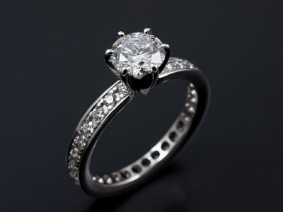 Round Brilliant 1.09ct E SI1 in a 6 Claw 18kt White Gold Setting with Pave Set Band.