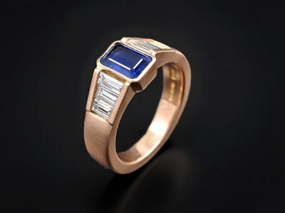 Emerald Cut Blue Ceylonese Sapphire 1.01ct with 6 x F VS Baguette Cut Diamonds 0.92ct total in an 18kt Rose Gold Rub Over and Channel Setting.