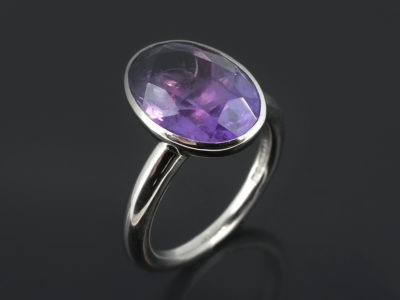 Coloured gemstone ring, 9kt white gold rub over design with 6 carat oval cut amethyst