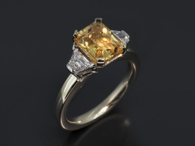 9kt Yellow Gold Basket Trilogy Design. Emerald Cut Yellow Sapphire 2.09ct.Trapezium Step Cut Side Diamonds, 0.35ct (2). F Colour VS Clarity Minimum
