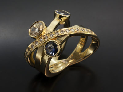 Ladies Crossover Design Dress Ring, 18kt Yellow Gold, Oval Cut Diamond 0.32ct, Sapphires 0.78ct (2), Pave Set Round Brilliant Cut Diamonds 0.19ct (20)