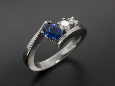 Oval Cut 1.09ct Sapphire and Round Brilliant Cut 0.27ct & 0.15ct Platinum Claw Set Twist