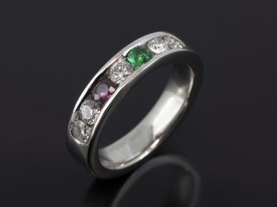 Platinum Channel Set Design. Round Brilliant Cut Diamonds, Approximately 0.55ct (5). F Colour, SI Clarity Minimum. Round Brilliant Cut Emerald, 3mm. Round Brilliant Cut Ruby, 3mm.