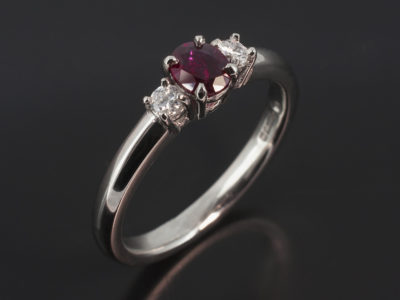 Platinum Claw Set Trilogy Design. Oval Cut Ruby, 0.34ct. Round Brilliant Cut Diamonds, 0.10ct (2). F-G Colour, SI Clarity