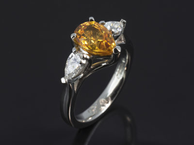 Platinum Claw Set Trilogy Design. Pear Shape Yellow Sapphire, 2.10ct. Pear Shape Diamonds, 0.60ct (2), F Colour VS Clarity Minimum