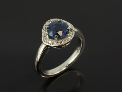 Round Sapphire 1.61ct and Round Brilliant Cut Diamond 0.08ct Total in a Platinum Claw and Pavé Set Halo Design