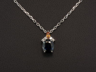 18kt White Gold Claw Set Sapphire and Diamond Pendant, Oval Dark Blue Sapphire 1.41ct, Marquise Cut Yellow Sapphire 0.11ct and Round Brilliant Cut Diamonds 0.05ct on an Angled Filed Trace Chain