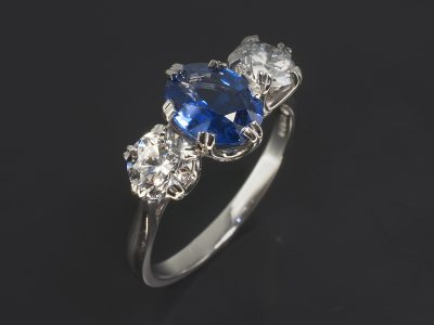 Platinum Claw Set Trilogy Design. Oval Cut Blue Sapphire, 1.74ct. Round Brilliant Cut Diamonds, 0.61ct, D Colour SI Clarity, Excellent Cut, Polish and Symmetry. 060ct, D Colour, SI1 Clarity, Excellent Cut, Polish and Symmetry.