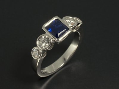 Platinum 5 Stone Rub Over Set Design Ring with Emerald Cut Sapphire 1.19ct and Round Brilliant Cut Diamonds 0.76ct Total