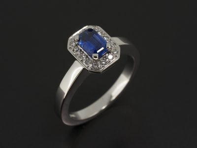 Platinum Halo Design with Emerald Cut Sapphire 0.50ct and Round Brilliant Cut Diamonds Pavé set into Halo