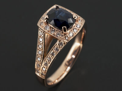 18kt Rose Gold Pavé Set Halo and Split Shoulder Design. Cushion Cut Midnight Blue Sapphire, 1.75ct. Round Brilliant Cut Diamonds Pavé Set