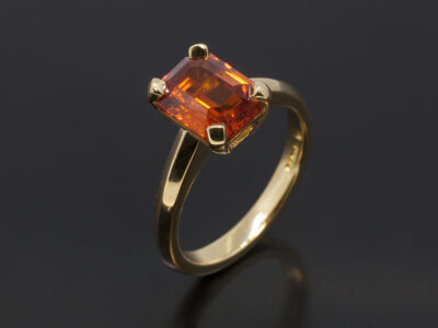 Ladies Sapphire Solitaire Dress Ring, 18kt Yellow Gold Claw Set Design, Emerald Cut Blood Orange Sapphire 2.67ct.