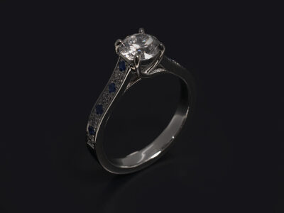 Ladies Diamond Engagement Ring, Platinum Claw and Pavé Set Design, Round Brilliant Cut Diamond, 0.70ct F Colour, SI2 Clarity, Pavé Set Round Brilliant Cut Diamonds 0.12ct (8), Pavé Set Round Blue Sapphires 0.12ct (8)