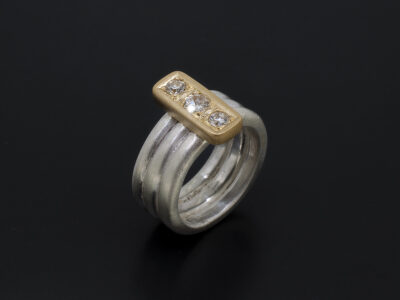 Ladies Trilogy Diamond Dress Ring, Silver and Gold, 3 diamonds in row in gold setting on 3 halo silver bands, brushed finish