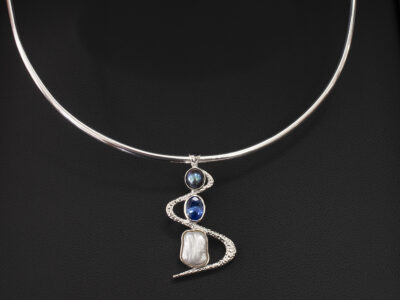 Silver Rub over Set Sapphire and Pearl Twist Design Pendant, Oval Cut Blue Sapphire 1.59ct, Peacock and Baroque Shape Pearl on a Silver Torque Necklace