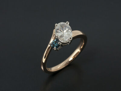 Ladies Blue Diamond Engagement Ring, Platinum and 18kt Rose Gold Claw Set Twist Design, Oval Cut Lab Grown Diamond 0.82ct, Round Brilliant Cut Blue Treated Diamond 0.10ct