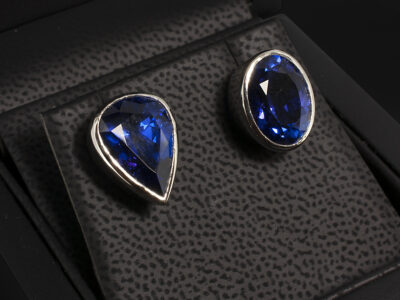 Platinum Rub over Set Tanzanite Stud Earrings, Pear and Oval Cut Tanzanites, 5.43ct and 5.09ct