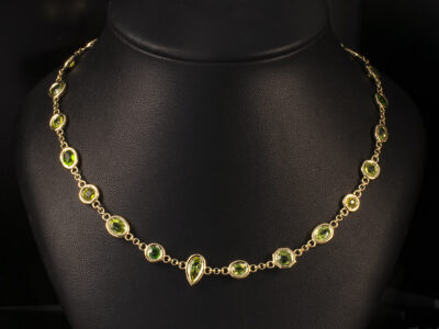 18kt Yellow Gold Rub Over set Necklace, Round Brilliant, Oval, Pear, and Hexagon Cut Peridots, 9.70ct Total (18)
