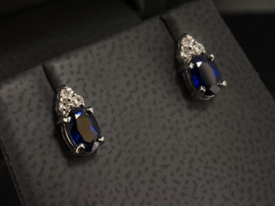 9kt White Gold Claw Set Sapphire and Diamond Studded Earrings, Oval Cut Blue Sapphires 1.02ct (2), Round Brilliant Cut Diamonds 0.05ct Total (6)