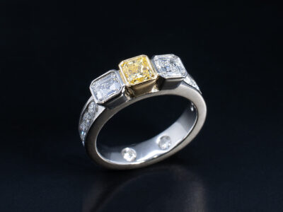 Ladies Diamond and Yellow Diamond Dress Ring, Platinum and 18kt Yellow Gold Rub over, Channel and Secret Set Design, Radiant Cut Yellow Diamond 0.55ct, Asscher Cut Diamonds 0.75ct Total (2), Round Brilliant Cut Diamonds 0.65ct Total (10)
