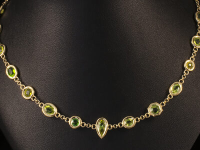 18kt Yellow Gold Rub Over set Necklace, Round Brilliant, Oval, Pear, and Hexagon Cut Peridots, 9.70ct Total (18)