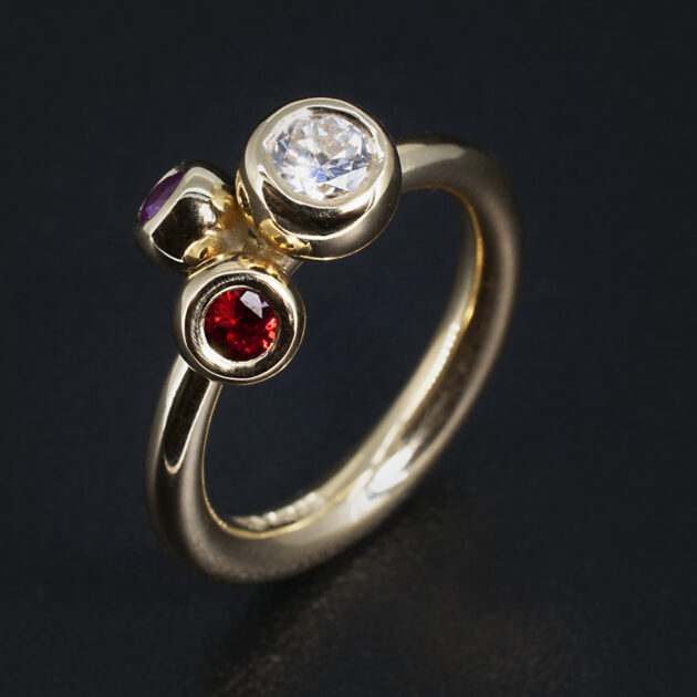 Kelvin Collection Yellow Gold Trilogy Ring Featuring a Round Diamond, Pink Sapphire and Blood Orange Sapphire by Blair and Sheridan