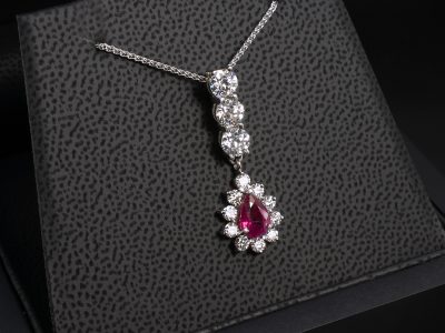 18kt White Gold Ruby and Diamond Halo Pendant, Claw Set Design, Pear Cut Ruby 1.02ct, Round Brilliant Cut Diamonds 1.13ct (3), Round Brilliant Cut Diamond Halo 0.45ct (10)